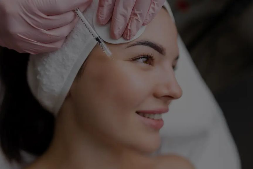 A smiling woman enjoying an expert massage service at Hand & Stone Massage and Facial Spa.